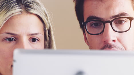 Happy-young-couple-watching-movie-on-digital-tablet-pc-computer-ipad